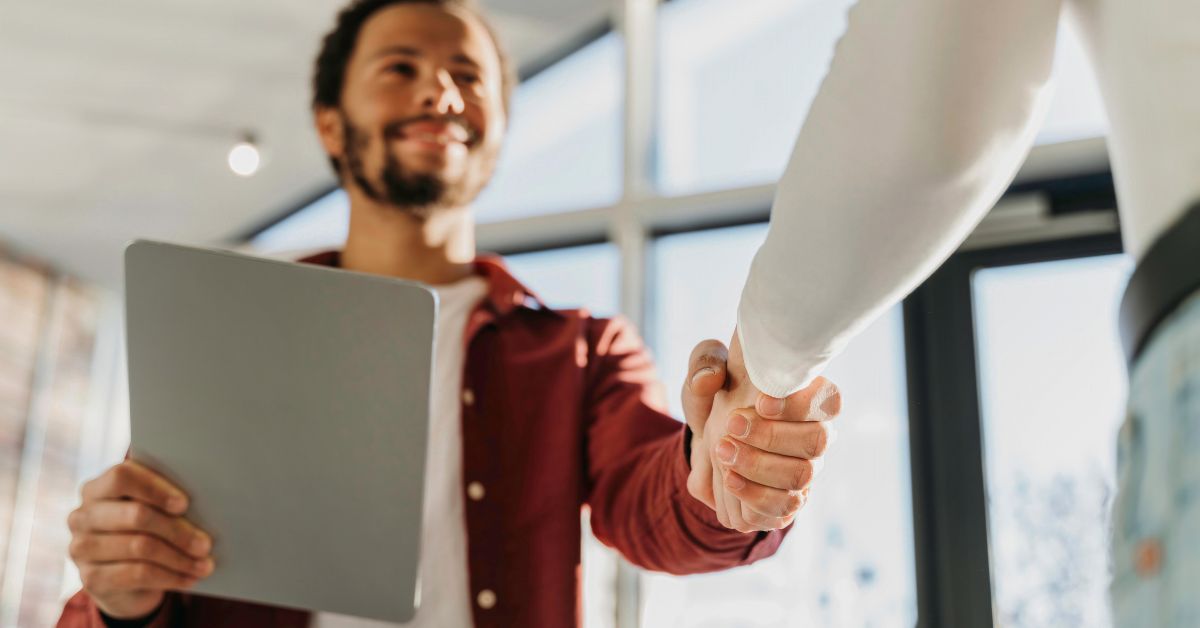 HR consultant shaking hands with a client, representing successful outsourced HR support.